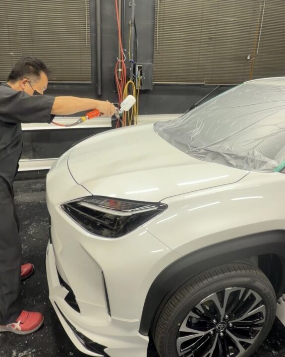 ヤリスクロスにコーティング専用プライマーをスプレーガンを使って塗布